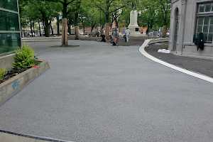Workers spread and level the gravel in preparation for the SolePave treatment.